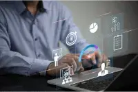 Person interacting with futuristic holographic interface on a laptop.