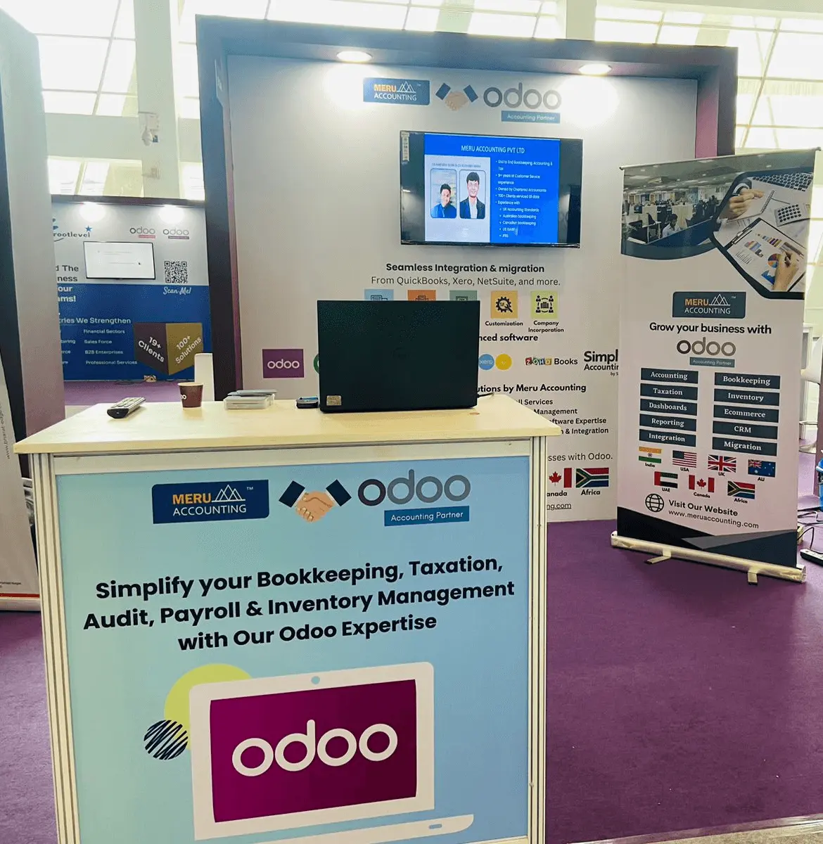 A booth featuring a laptop and a sign displaying the word "odooo," set up for a promotional or informational purpose.